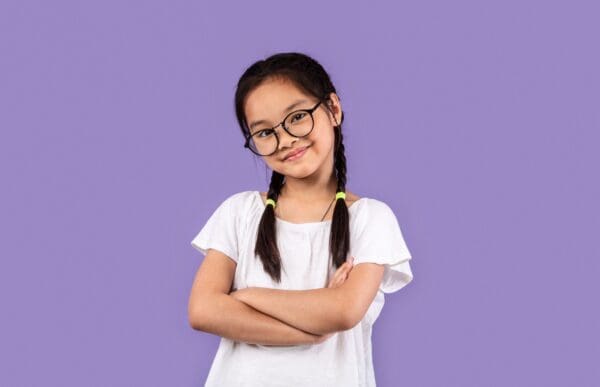 A girl with glasses and pigtails posing for the camera.