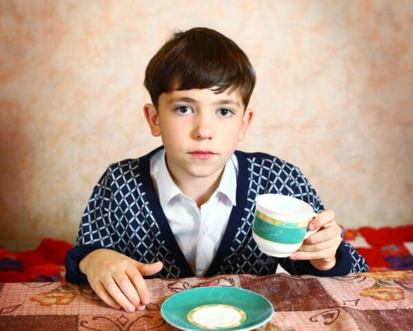A boy sitting at the table with a bowl of cereal.